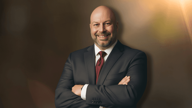 Professional portrait of Heiko Gärtner smiling in a dark suit with arms crossed.