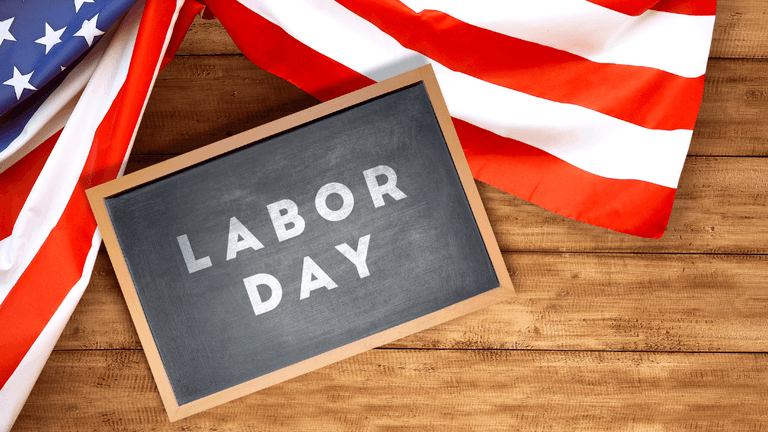 Labor Day sign on a wooden surface with an American flag backdrop