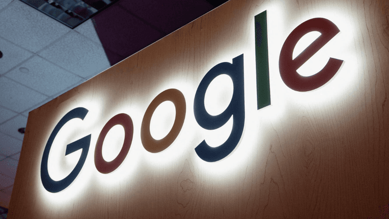 Lit Google logo in vibrant colors on a wooden background