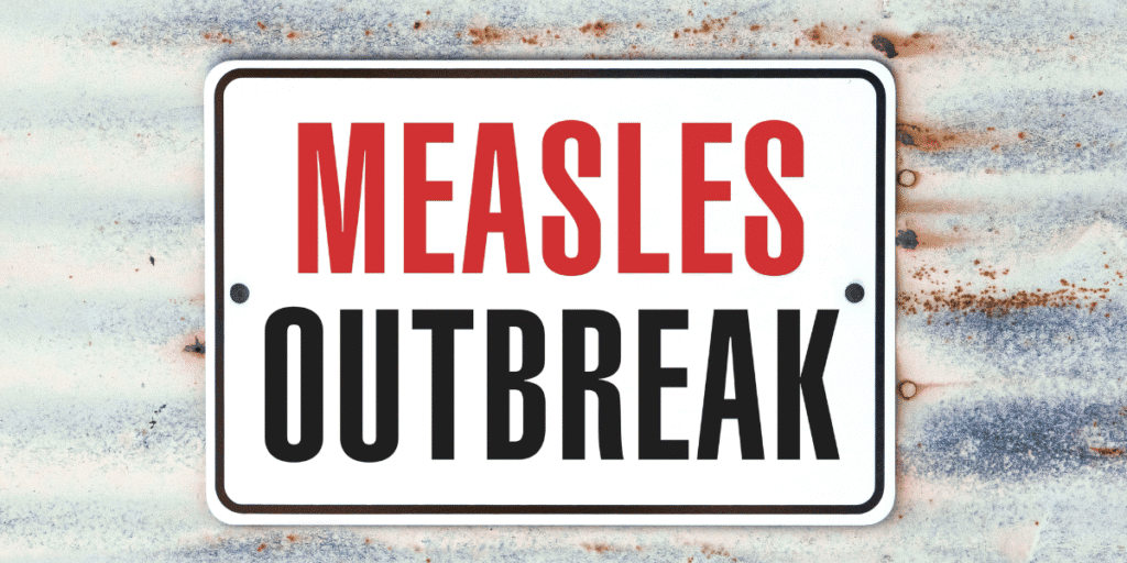 WHO Calls for Stronger Global Immunization Efforts as Measles Cases Continue to Rise Sign reading "Measles Outbreak" against a weathered metal background.